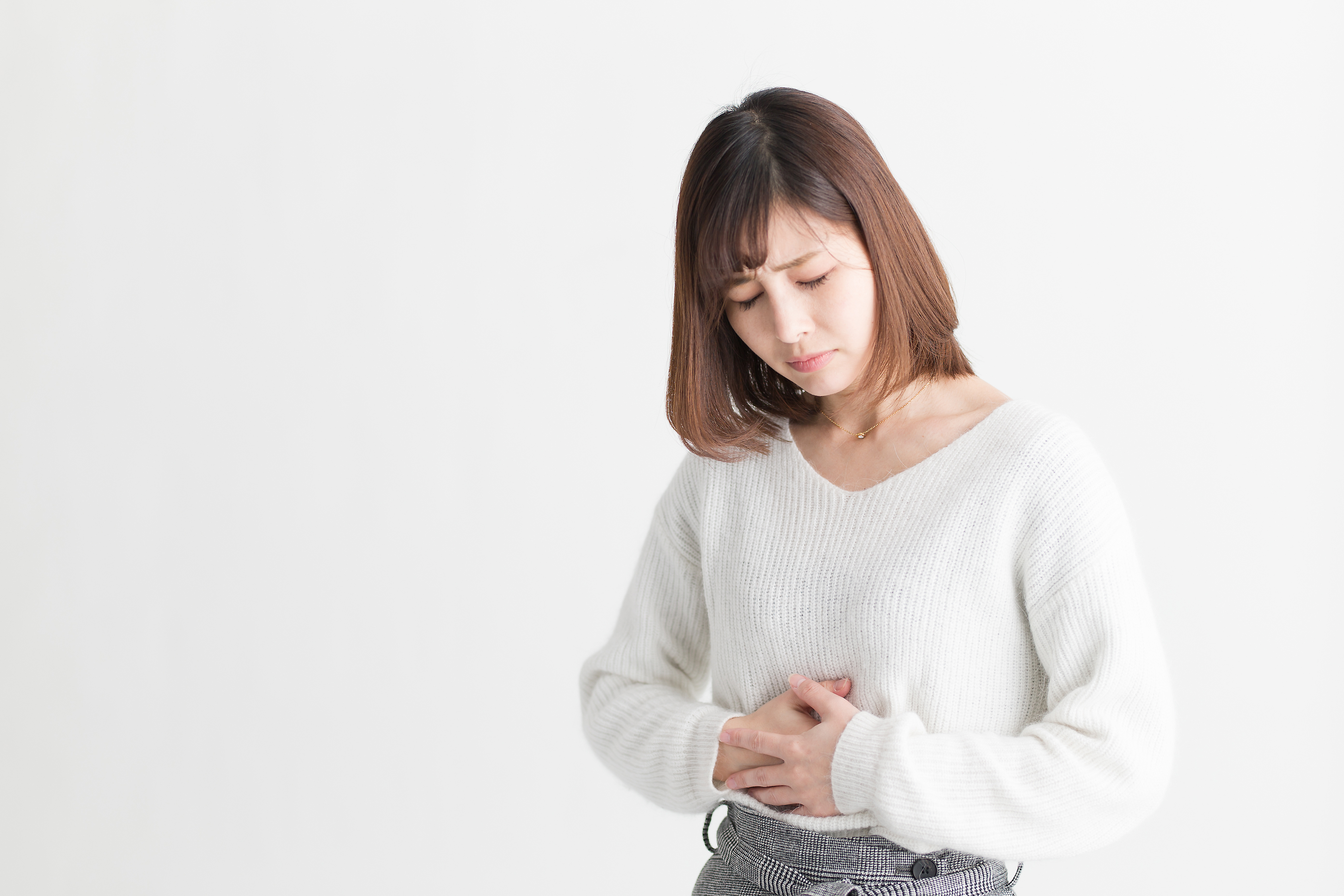 お腹を抑える女性