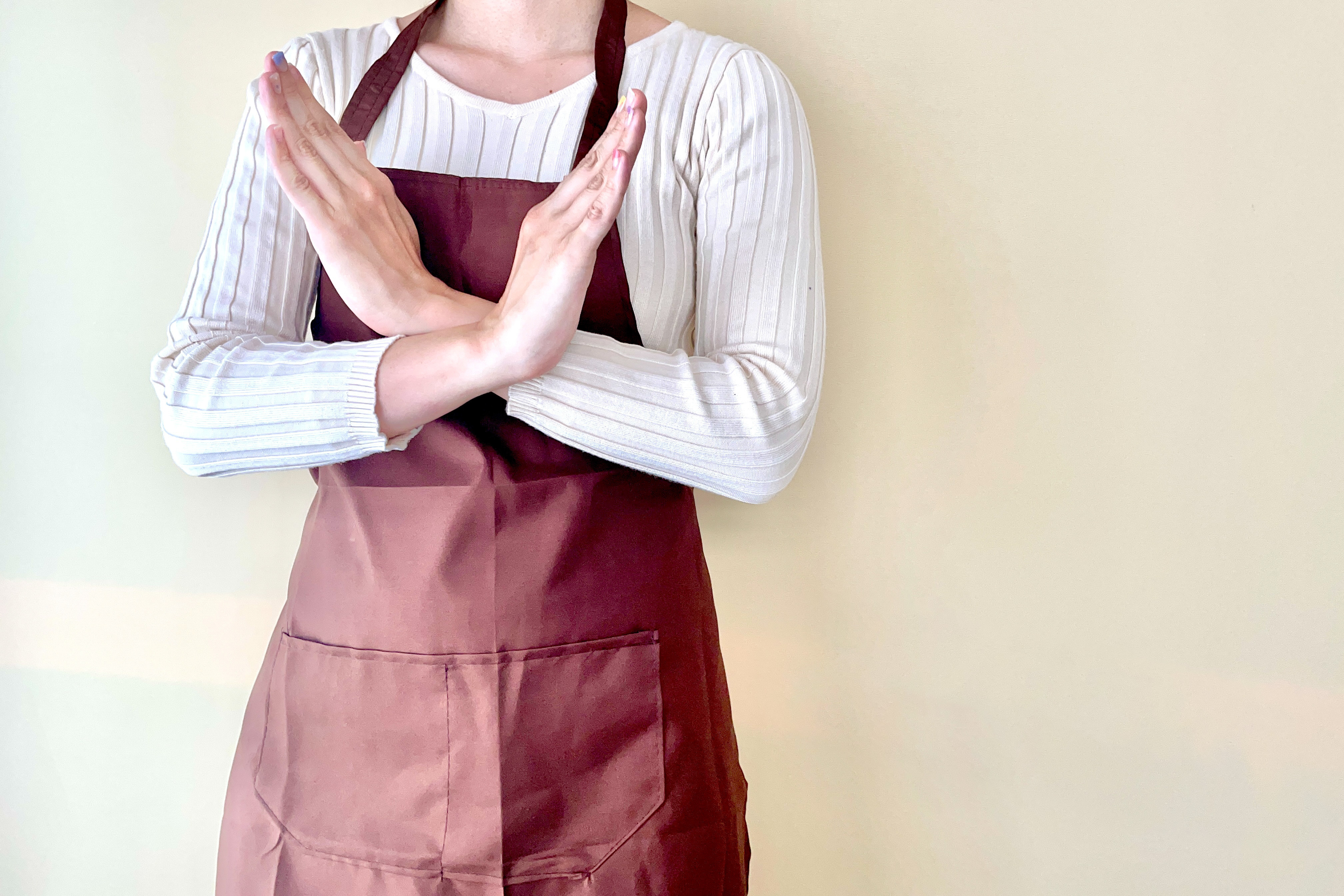 手でバツを作る女性