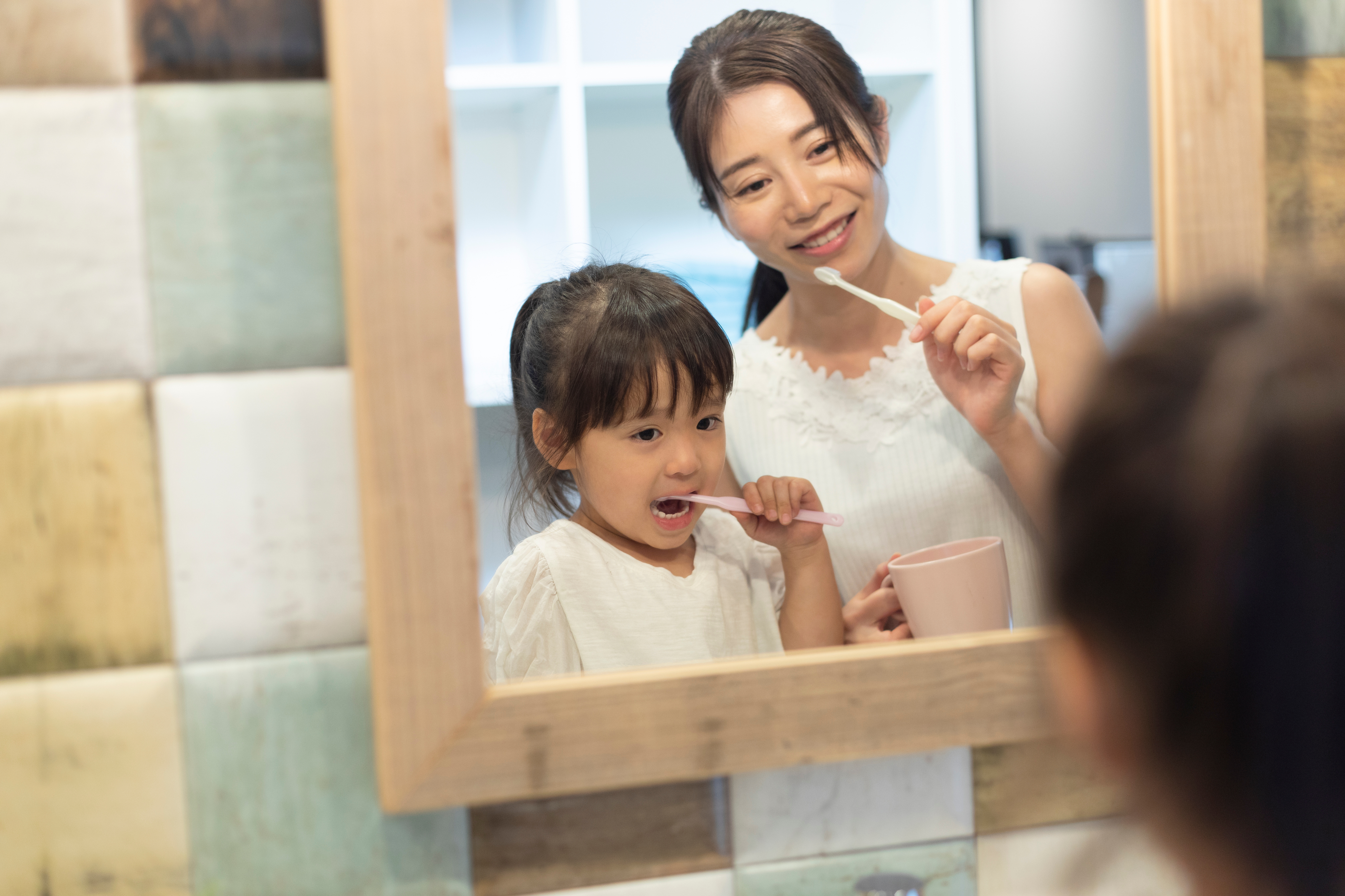 鏡の前で歯磨きをする親子