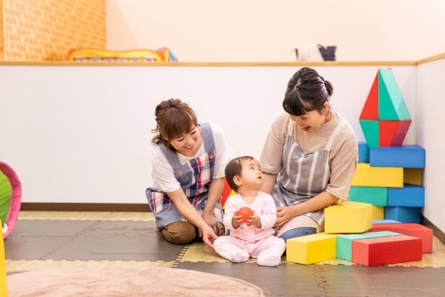 保育施設で遊ぶ乳児と保育士